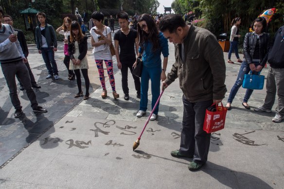 This gentleman was practicing calligraphy on the sidewalk using water for ink. He was writing poetry of course.